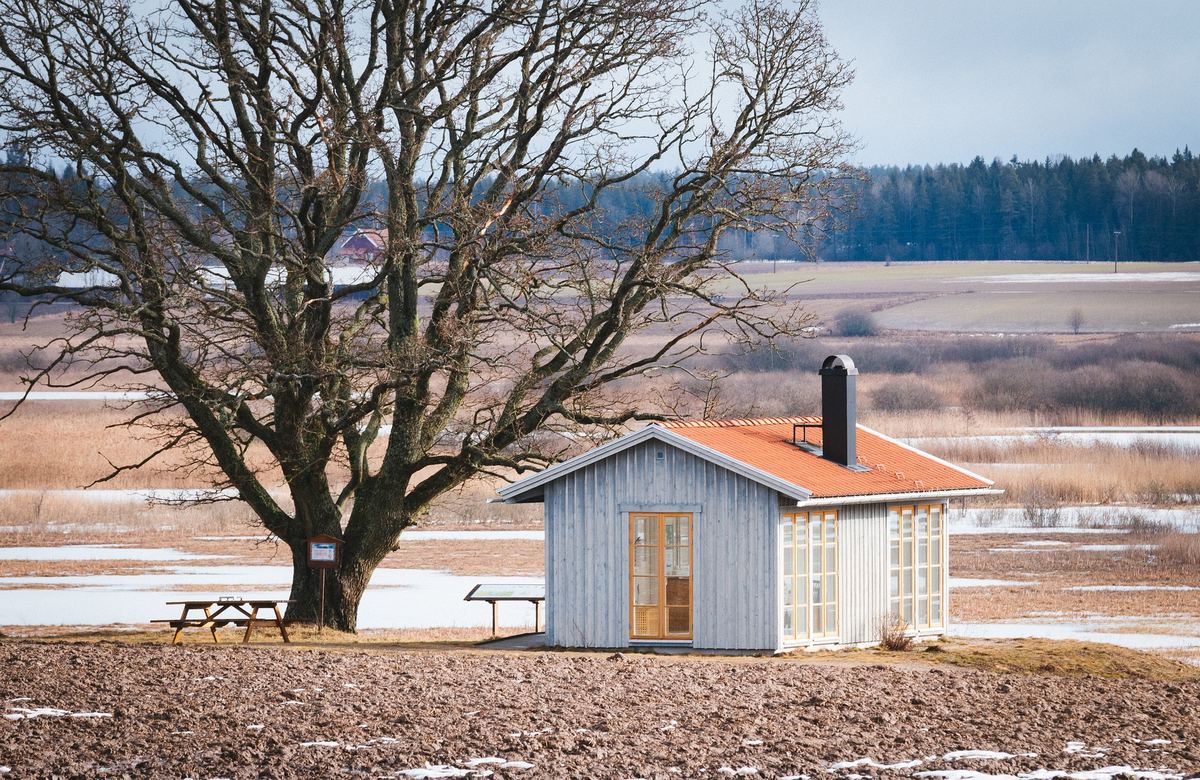 Liten stuga vid en åkerkant en vinterdag